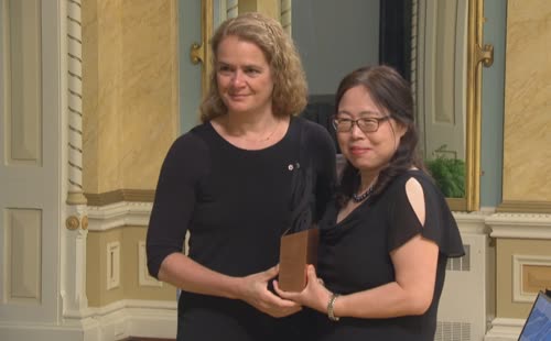 Qiu accepts an award from Gov. Gen. Julie Payette, left, at a ceremony at Rideau Hall in 2018, for being part of the team at the National Microbiology Lab that created the Ebola drug ZMapp. (CBC)