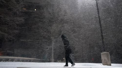 A woman walks through falling snow in San Antonio, Texas. Snow and ice blanketed large swaths of the U.S. on Sunday, prompting canceled flights, making driving perilous and reaching into areas as far south as the state's Gulf Coast.