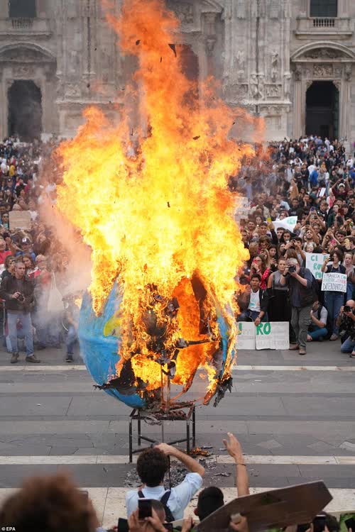 Burning a plastic globe to protest pollution and plastics. Or to keep warm. Either way it makes no sense.