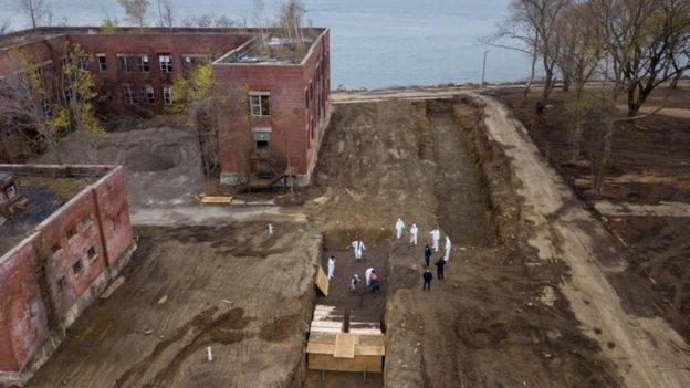 Images have emerged of coffins being buried in a mass grave in New York City, as the death toll from the coronavirus continues to rise.