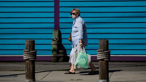 A woman wearing a mask walks in downtown Steveston, B.C., on Monday. (Ben Nelms - CBC)